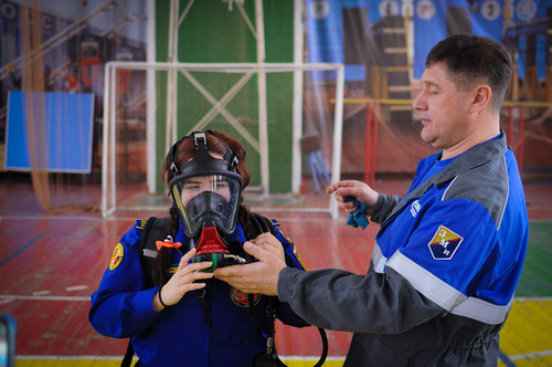 Респираторщик заводского военизированного отряда Николай Голиков объясняет правила применения дыхательного аппарата