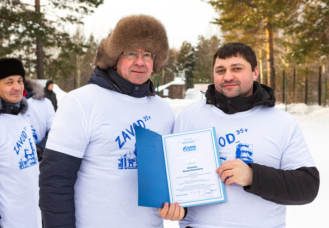 Валерий  Кузьменок, заместитель директора завода награждает Михаила Атрошонка, электромонтера по ремонту и обслуживанию электрооборудования