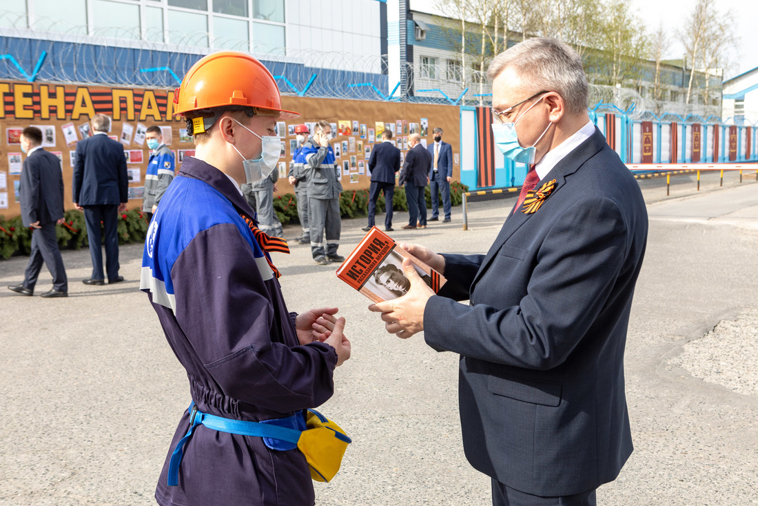 Директор завода Андрей Дорощук вручает памятное издание Виталию Янину, ведущему инженеру-технологу технического отдела